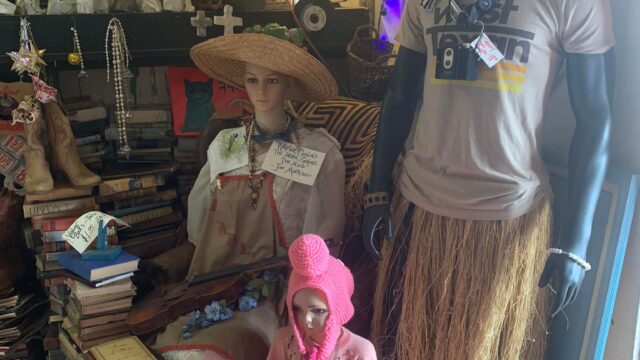 Mannequins dressed in eclectic, cultural attire display.