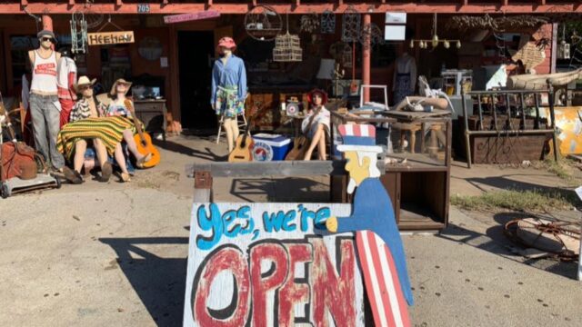 Outdoor antique shop with open sign displayed.