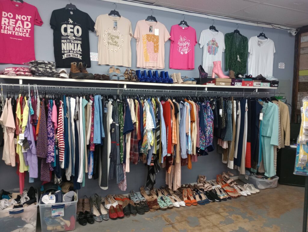 Clothing store display with shirts and shoes.