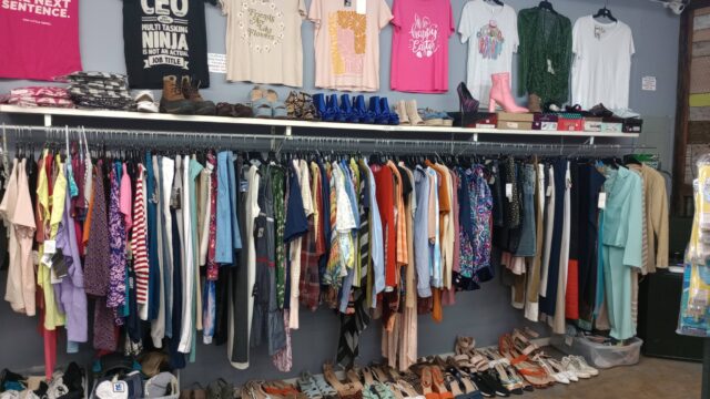 Clothing store display with shirts and shoes.