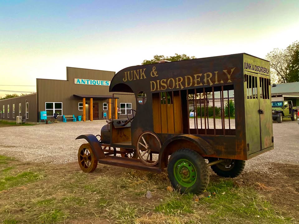 Vintage vehicle outside antique store.