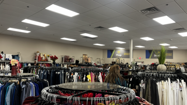 Thrift store clothing racks and bright lighting.